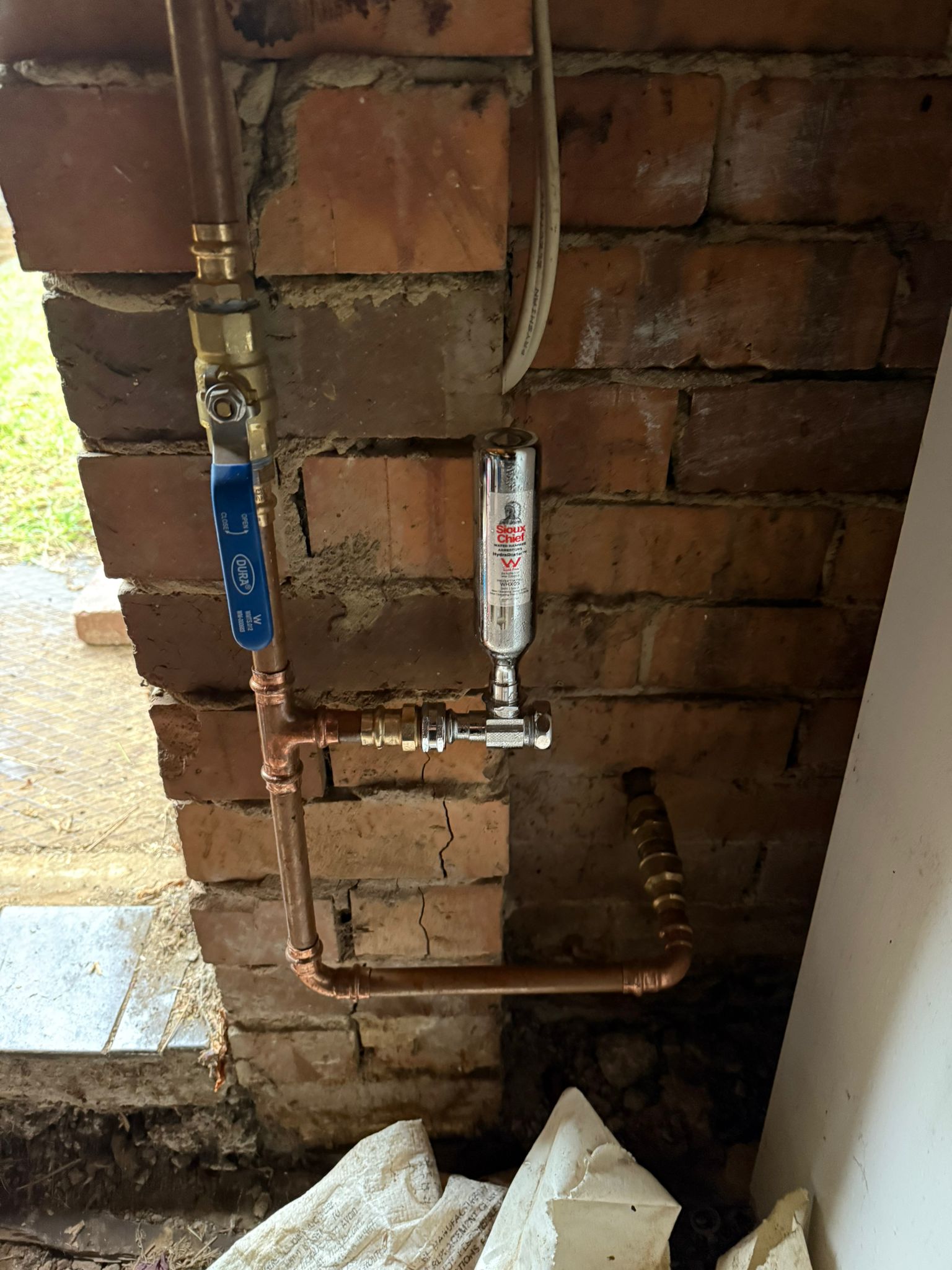 Sioux Chief water hammer arrestor and copper ball valve installed on brick wall Ivanhoe Melbourne